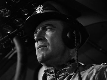 An older man wearing a hat and ear phones