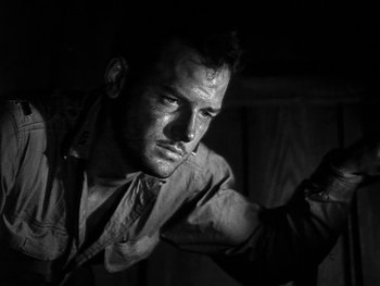Movie still from “Air Force” (1943), directed by Howard Hawks – Black and white photograph of a man in a dark room; Close Up shot, Low angle