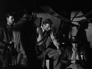 Movie still from “Air Force” (1943), directed by Howard Hawks – A group of men sitting on top of each other; Medium shot, Low angle