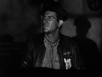 Movie still from “Air Force” (1943), directed by Howard Hawks – A man wearing a hat and a leather jacket; Close Up shot, Low angle