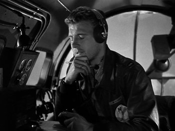 Movie still from “Air Force” (1943), directed by Howard Hawks – A black and white photo of a man in a helicopter cockpit; Medium shot, Low angle