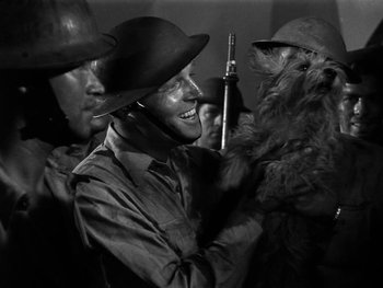 Movie still from “Air Force” (1943), directed by Howard Hawks – A group of men standing next to each other holding guns; Medium shot, High angle