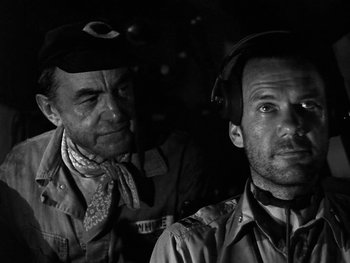 Movie still from “Air Force” (1943), directed by Howard Hawks – A black - and - white photo of two men in military uniforms; Close Up shot, Over the shoulder angle