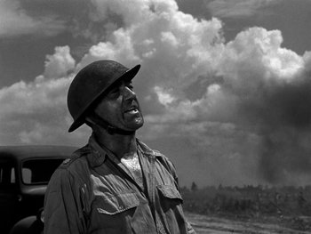 Movie still from “Air Force” (1943), directed by Howard Hawks – An old photo of a man wearing a hat; Medium shot, Low angle