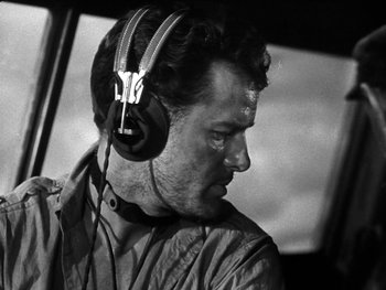 Movie still from “Air Force” (1943), directed by Howard Hawks – Black and white photograph of a man wearing headphones; Close Up shot, Low angle