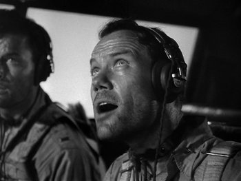Movie still from “Air Force” (1943), directed by Howard Hawks – A black and white photo of a man with headphones; Close Up shot, Low angle