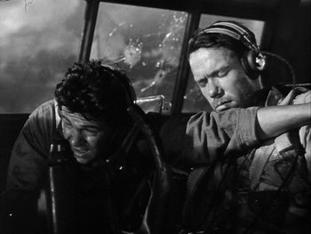 Movie still from “Air Force” (1943), directed by Howard Hawks – A black and white photo of two men in a helicopter; Medium shot, Low angle