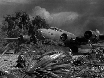 Movie still from “Air Force” (1943), directed by Howard Hawks – An old airplane sitting on top of a dirt field; Extreme Wide shot, Low angle