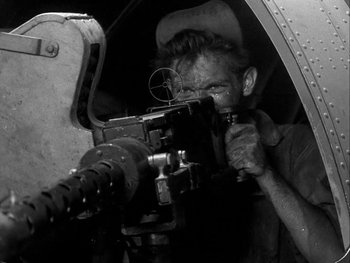 Movie still from “Air Force” (1943), directed by Howard Hawks – A man is holding a gun in his hand; Medium shot, Low angle