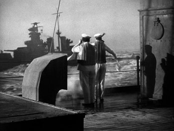 Movie still from “Air Force” (1943), directed by Howard Hawks – Two men in sailor's uniforms on the deck of a boat; Wide shot, Low angle