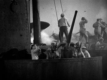 Movie still from “Air Force” (1943), directed by Howard Hawks – A black and white photo of men working on a ship; Extreme Wide shot, High angle