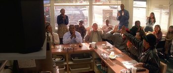 A group of people sitting at a table in front of a window