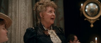 Movie still from “Albert Nobbs” (2011), directed by Rodrigo García – An older woman wearing a black dress and a black and white blouse; Close Up shot, Over the shoulder angle