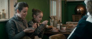 Movie still from “Albert Nobbs” (2011), directed by Rodrigo García – Two children are sitting at a table eating food; Medium shot, Over the shoulder angle