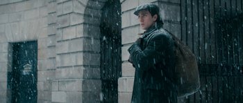 Movie still from “Albert Nobbs” (2011), directed by Rodrigo García – A man standing in the snow with his arms crossed; Medium shot, Low angle
