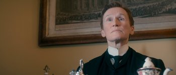 Movie still from “Albert Nobbs” (2011), directed by Rodrigo García – A man wearing a suit and tie looking up; Close Up shot, Low angle