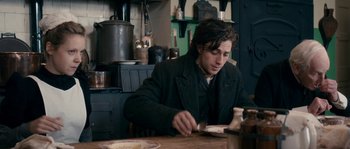 Movie still from “Albert Nobbs” (2011), directed by Rodrigo García – A man sitting at a table with a plate of food in front of him; Medium shot, High angle