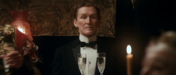 Movie still from “Albert Nobbs” (2011), directed by Rodrigo García – A man in a tuxedo holding two glasses of champagne; Close Up shot, Low angle