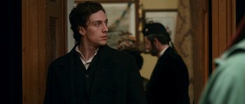 Movie still from “Albert Nobbs” (2011), directed by Rodrigo García – A man wearing a suit and tie standing next to another man wearing a suit and tie; Close Up shot, Low angle