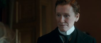 Movie still from “Albert Nobbs” (2011), directed by Rodrigo García – A man in a suit and tie looking to his left; Close Up shot, Over the shoulder angle