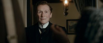 Movie still from “Albert Nobbs” (2011), directed by Rodrigo García – An older man wearing a suit and a tie; Close Up shot, Over the shoulder angle