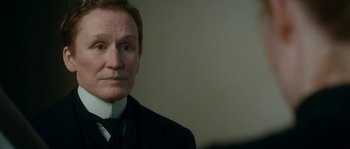 Movie still from “Albert Nobbs” (2011), directed by Rodrigo García – A person wearing a suit and tie; Close Up shot, Over the shoulder angle