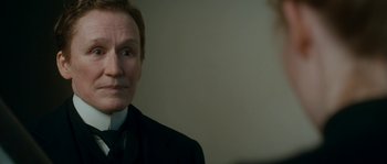 Movie still from “Albert Nobbs” (2011), directed by Rodrigo García – A man in a black suit and white shirt; Close Up shot, Over the shoulder angle