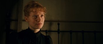 Movie still from “Albert Nobbs” (2011), directed by Rodrigo García – A woman with red hair wearing a black shirt; Close Up shot, Over the shoulder angle