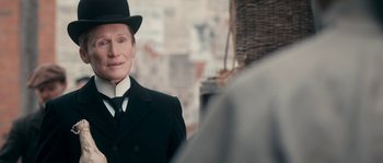 Movie still from “Albert Nobbs” (2011), directed by Rodrigo García – A person wearing a suit and a top hat; Close Up shot, Over the shoulder angle
