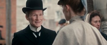 Movie still from “Albert Nobbs” (2011), directed by Rodrigo García – A man wearing a top hat and a black suit; Close Up shot, Over the shoulder angle