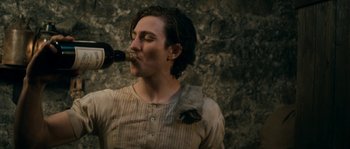 Movie still from “Albert Nobbs” (2011), directed by Rodrigo García – A man drinking a bottle of wine from a wine bottle; Close Up shot, High angle