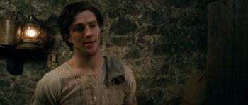 Movie still from “Albert Nobbs” (2011), directed by Rodrigo García – A man with a beard is standing in front of a stone wall; Close Up shot, Over the shoulder angle