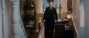 Movie still from “Albert Nobbs” (2011), directed by Rodrigo García – A man in a suit standing next to a desk; Medium shot, Low angle