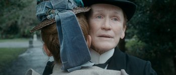 Movie still from “Albert Nobbs” (2011), directed by Rodrigo García – An older woman wearing a hat and a tie; Close Up shot, Over the shoulder angle