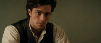 Movie still from “Albert Nobbs” (2011), directed by Rodrigo García – A man with long dark hair wearing a vest; Close Up shot, Over the shoulder angle