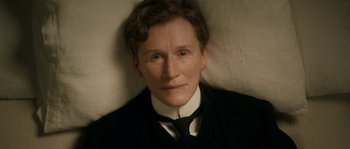 Movie still from “Albert Nobbs” (2011), directed by Rodrigo García – A man wearing a suit and tie with his head tilted to the side; Close Up shot, High angle