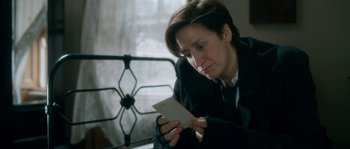 Movie still from “Albert Nobbs” (2011), directed by Rodrigo García – A woman looking down at a piece of paper; Close Up shot, Over the shoulder angle