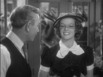 Movie still from “Alice Adams” (1935), directed by George Stevens – A man and a woman smiling for the camera; Medium shot, Over the shoulder angle
