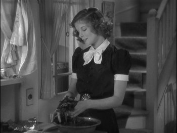Movie still from “Alice Adams” (1935), directed by George Stevens – A woman in a black and white photo preparing food; Medium shot, High angle