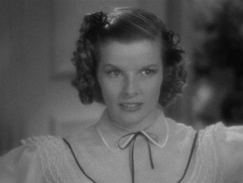 Movie still from “Alice Adams” (1935), directed by George Stevens – A black and white photo of a woman in a white dress; Close Up shot, High angle