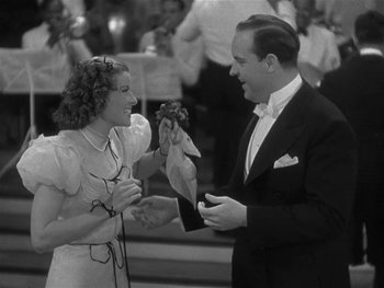 Movie still from “Alice Adams” (1935), directed by George Stevens – A man and a woman are holding a stuffed animal; Medium shot, High angle