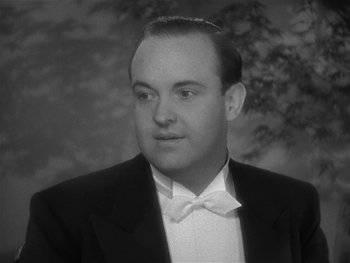 Movie still from “Alice Adams” (1935), directed by George Stevens – An old photo of a man in a suit and bow tie; Close Up shot, Low angle