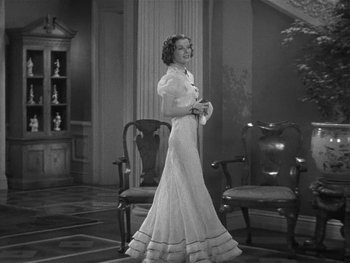 Movie still from “Alice Adams” (1935), directed by George Stevens – An old photo of a woman standing in a room; Medium shot, Low angle