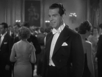 Movie still from “Alice Adams” (1935), directed by George Stevens – A man in a tuxedo standing in front of a group of people; Medium shot, Low angle