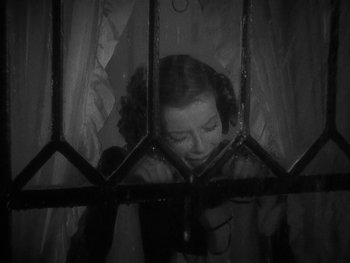 Movie still from “Alice Adams” (1935), directed by George Stevens – A black - and - white photo of a woman behind bars; Close Up shot, Low angle