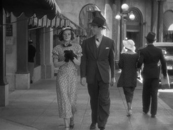 Movie still from “Alice Adams” (1935), directed by George Stevens – An old photo of a man and a woman walking down the street; Wide shot, High angle