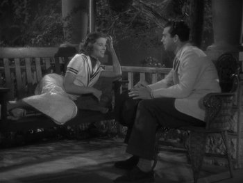 Movie still from “Alice Adams” (1935), directed by George Stevens – A man and a woman sitting on a porch swing; Medium shot, High angle
