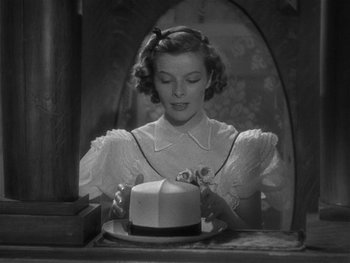 Movie still from “Alice Adams” (1935), directed by George Stevens – A black - and - white photo of a woman holding a cake; Close Up shot, High angle