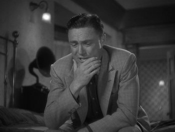 Movie still from “Alice Adams” (1935), directed by George Stevens – A man in a suit and tie sitting on the ground; Close Up shot, High angle