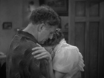 Movie still from “Alice Adams” (1935), directed by George Stevens – A man and a woman embracing each other in front of a wall; Medium shot, High angle